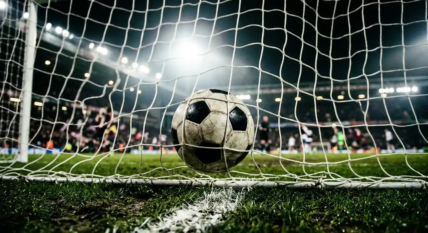 En fotball i nettet bak en målstang på en VM-arena under flomlys